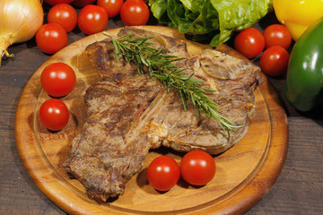 Grilled T bone steak with rosemary tomatoes, paprika onions and