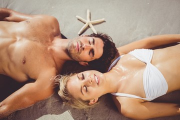 Couple lying on beach - Powered by Adobe