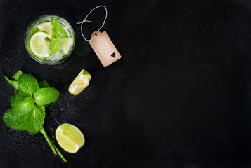 Fresh juicy mojito in glasse on a dark stone background, top view