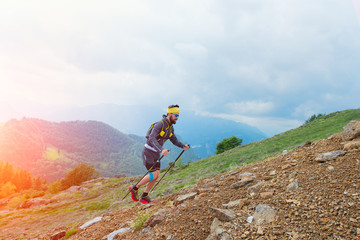 Skyrunner athlete while training in the mountains with sticks