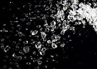 Water splash isolated on black background.  drops levitate in the air  dark