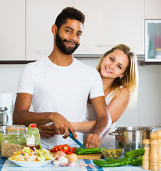 Obraz na płótnie Canvas Interracial couple cooking vegetables