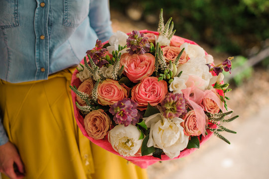 girl holding Bouquet of the different mixed orange and white flowers