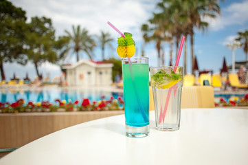 Cool cocktails against the backdrop of palm trees and a swimming pool