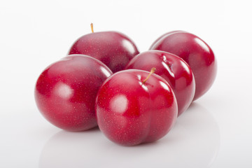 Red plums on white background