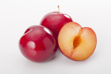 Red plums on white background