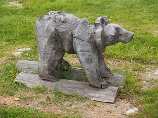 wooden figurine of a bear on the grass