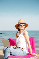 Fototapeta na wymiar Woman with laptop on the beach