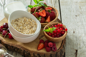 Oatmeal with berries on rustic wood background