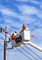 Electricians  repairing wire of the power line on basket hydraulic lifting platform vehicle  