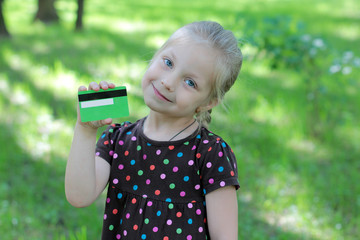 Russian child with a credit card in nature