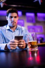 Man using mobile phone at bar counter