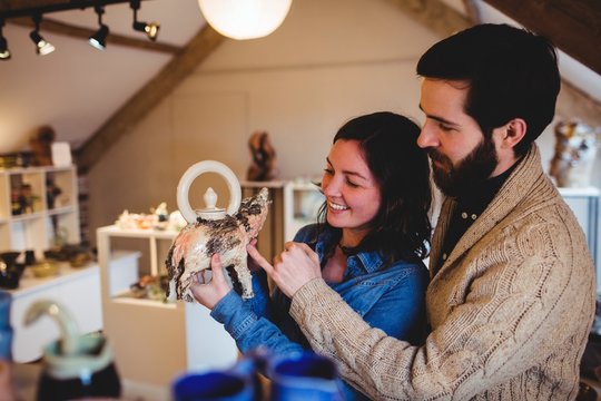 Smiling buyers with figurine at pottery store
