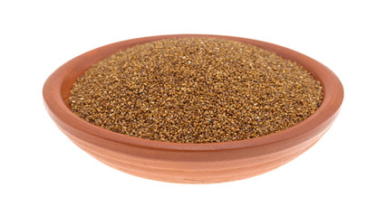 Teff grain filling a small bowl on a white background side view.