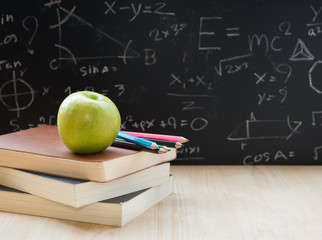 Education element, book, pencil, green apple on desktop and back