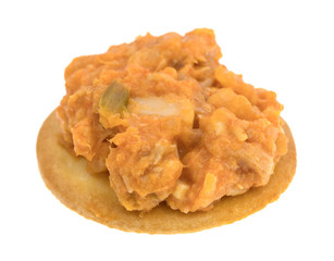 Spicy chicken salad on butter cracker side view isolated on a white background.