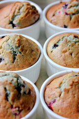Muffin with berries in white ramekin after baking
