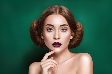 Attractive mysterious young woman with double hair bun in Princess Leia hairstyle looks towards the...