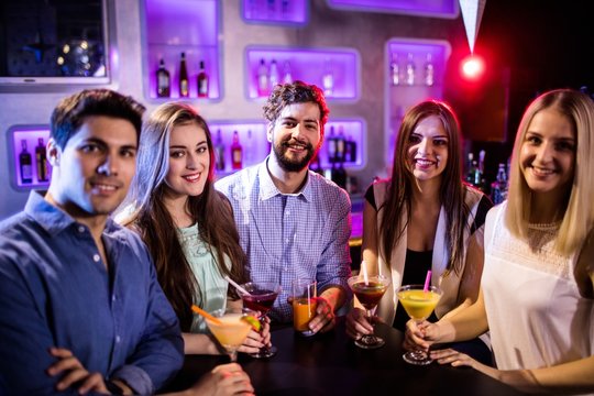 Group of friends having cocktail at bar counter