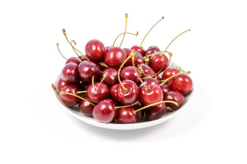 Small heap of ripe sweet cherry on the plate isolated on white background