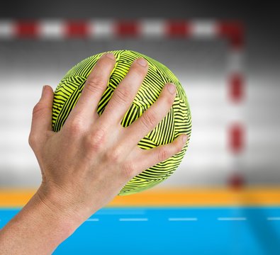 Composite image of sportswoman holding a ball