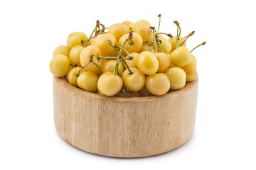 Wooden bowl filled with fresh ripe organic white cherries, isolated on white background
