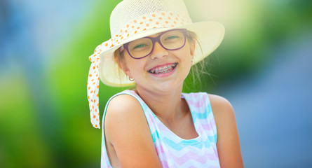 Girl.Happy girl teen pre teen. Girl with glasses. Girl with teeth braces. Young cute caucasian blond girl in summer outfit.