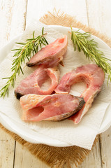 raw carp steak with paper kitchen towel and rosemary