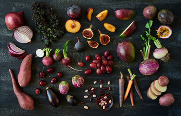 Different purple fruit and vegetables on dark background