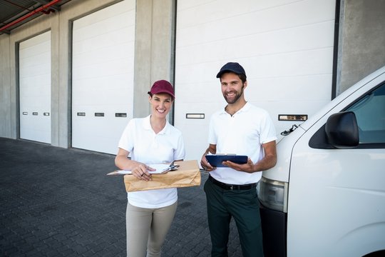Portrait of delivery people are holding goods and posing