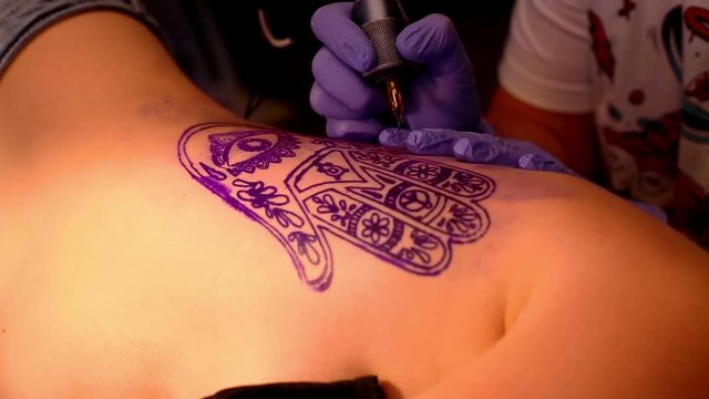 Master makes a tattoo
