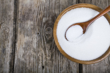 Sugar and spoon in a wooden bowl