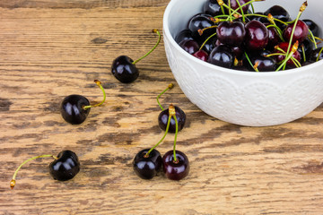 Red cherries in a white ceramic bowl.