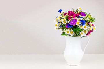 Wildflowers in white ceramic jug.