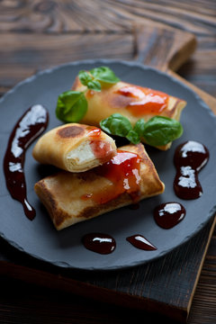 Crepes stuffed with cottage cheese and served with jam, close-up