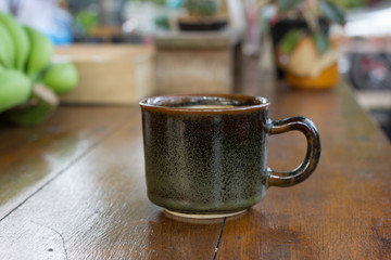 Cup of hot coffee , black coffee with foam.