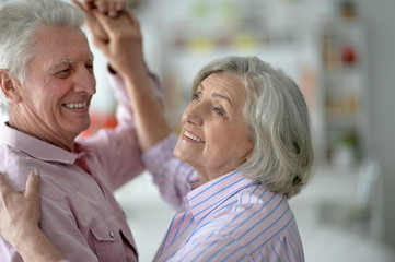 happy senior couple dancing at home