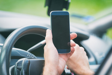 Man with smart phone in the car