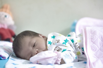 Newborn girl sleeping in her bed