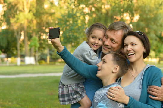 family taking selfie in park