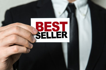 Business man holding a card with the text: Best Seller