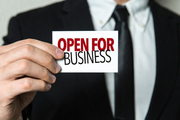 Business man holding a card with the text: Open for Business