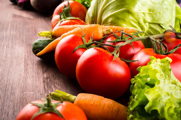 Fresh vegetables: cabbage, beet, carrots, tomatoes, parsley, on a wooden table. Space for text.