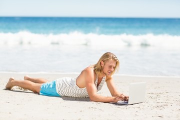 Man using laptop on beach