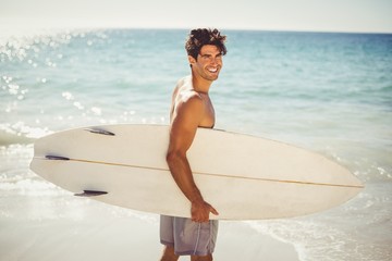 Man holding surfboard on beach