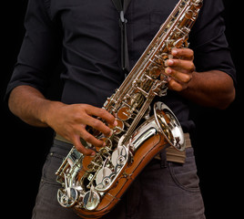 Close up of nice saxophone, silver one with someone touching it