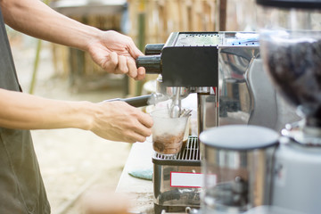Barista mixing milk and chocolate on espresso machine for making