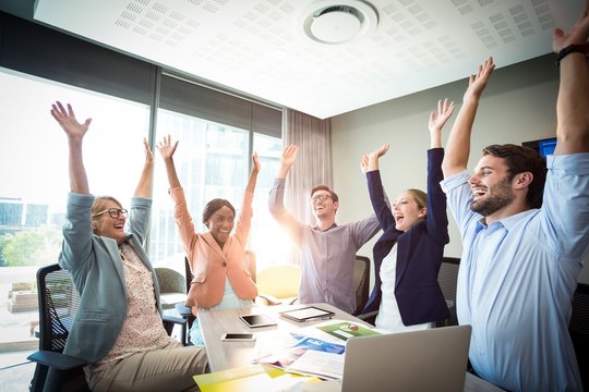 Business people raising their arms
