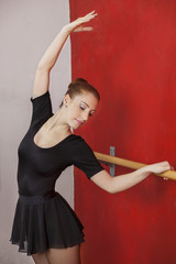 Ballet Dancer Stretching At Barre In Studio