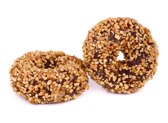 A pair of peanut covered donuts over white.
